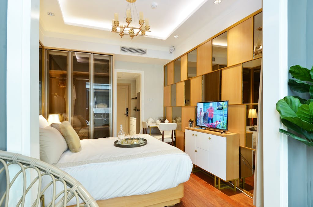 Luxurious hotel room featuring modern interior design with a comfortable bed, stylish furnishings, and ambient lighting.