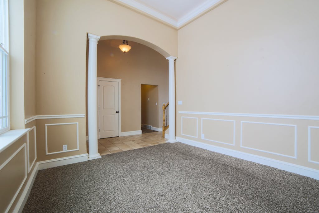Spacious interior with carpet flooring and classic architectural details.
